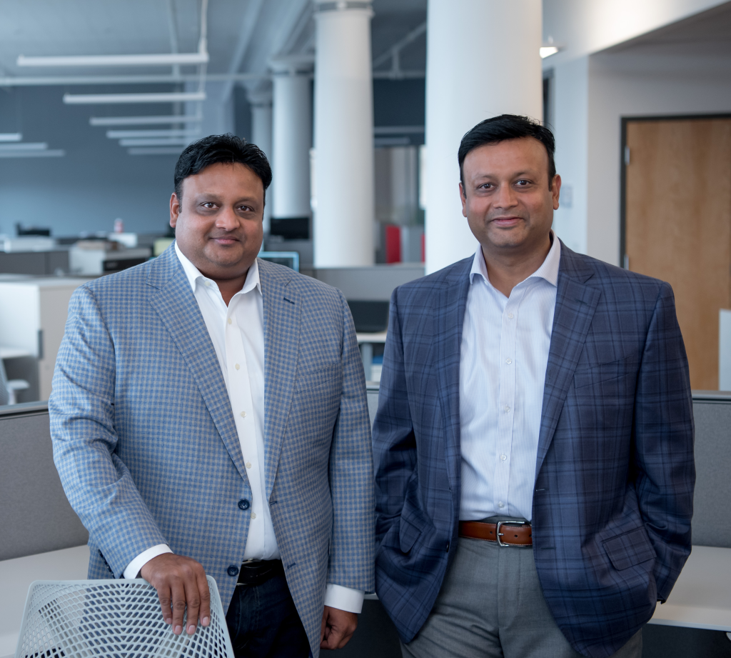 Pictured are two men in an office. Pictured left is Vikram Agrawal and right is Vikash Agrawal.